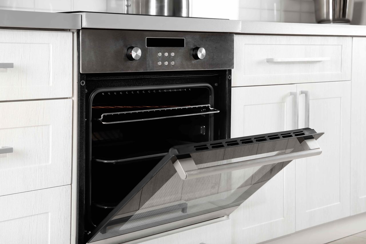 A clean stainless steel oven with its door dropped open in a white Emsworth kitchen